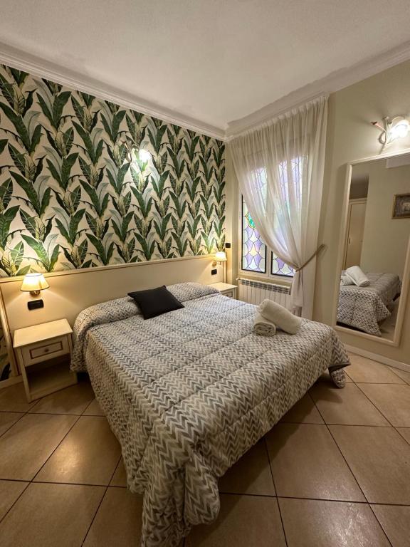 1 dormitorio con 1 cama y un mural en la pared en Camere Chicca, en San Remo