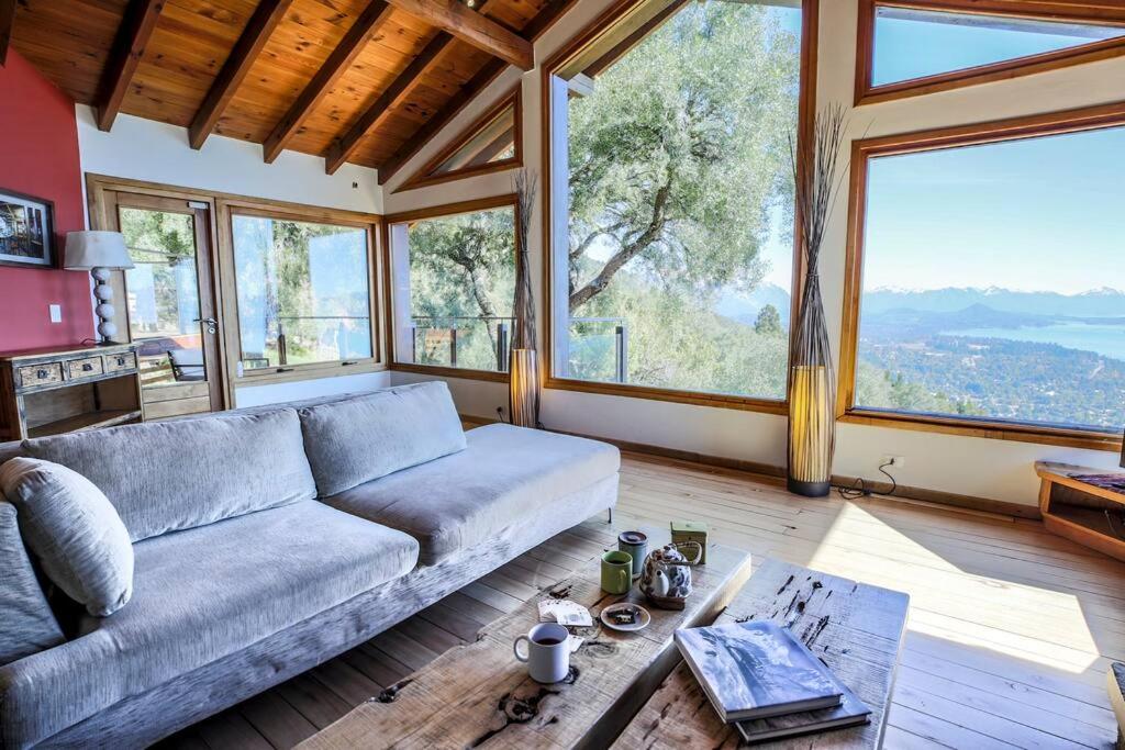 sala de estar con sofá y ventanas grandes en Casa Karine - Vue imprenable et dolce vita en San Carlos de Bariloche