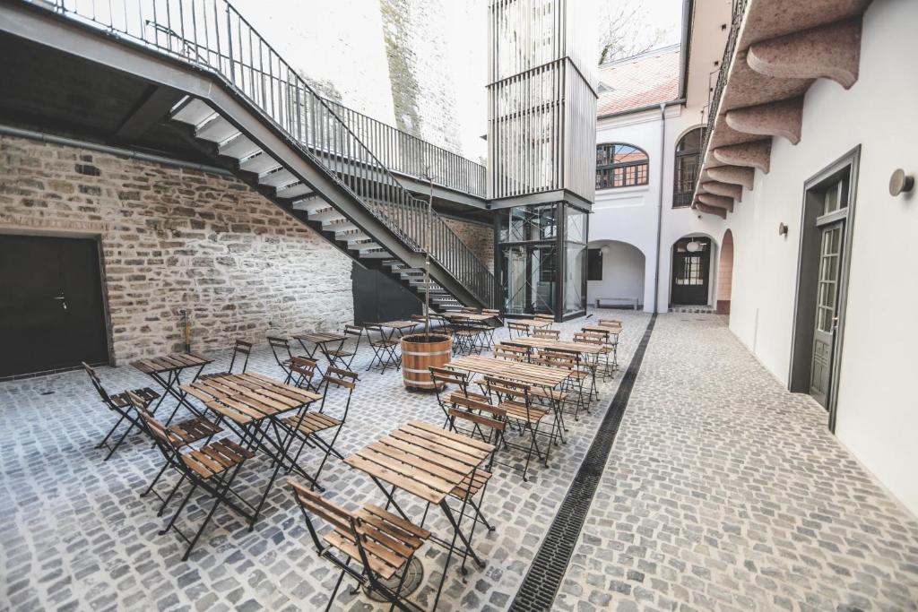 a patio with tables and chairs and a staircase at Ruttner Ház in Veszprém