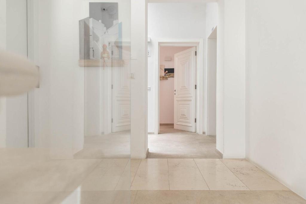 un corridoio vuoto con pareti bianche e pavimenti bianchi di Palazzo Novecento a Polignano a Mare