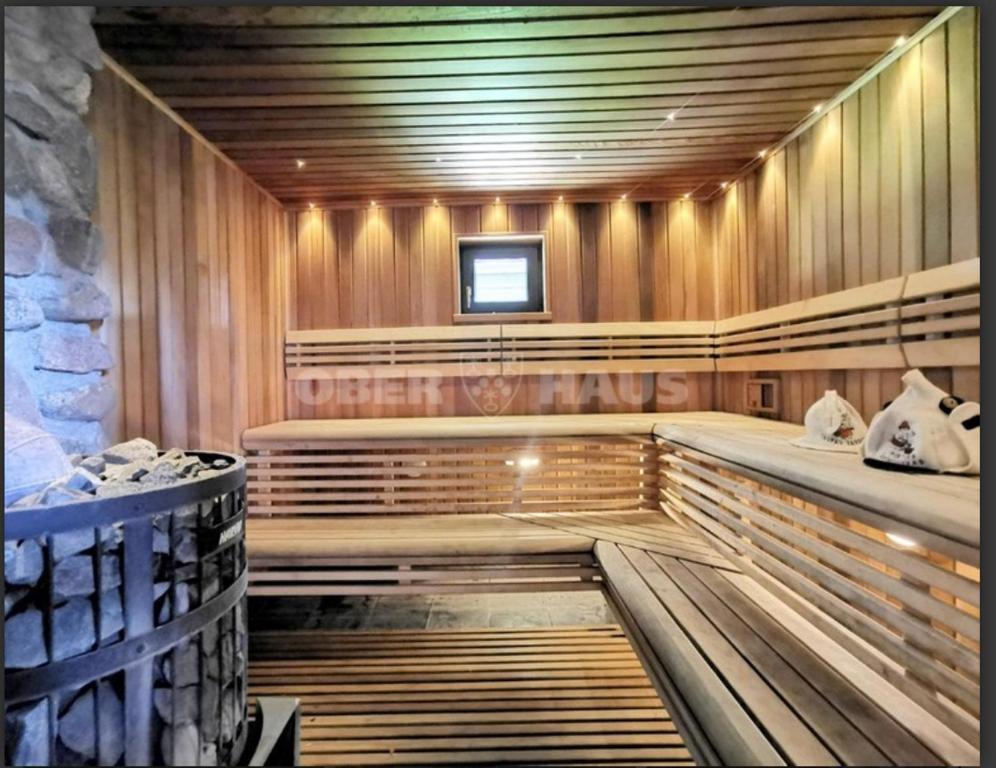 a sauna with wooden walls and a tv on the wall at Vila Dona in Varėna