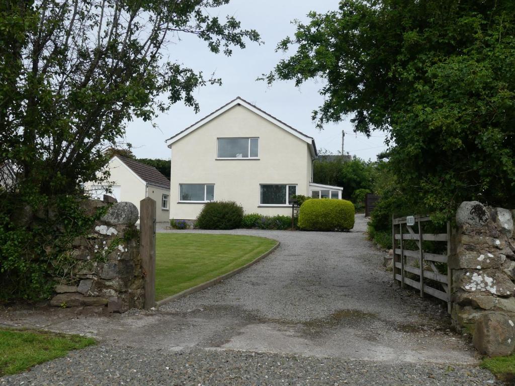 a white house with a gate and a driveway at Millfield in Rockcliffe