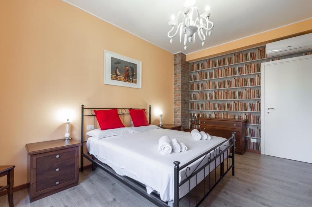 - une chambre avec un grand lit et des oreillers rouges dans l'établissement Mila Apartments Brizi, à Milan