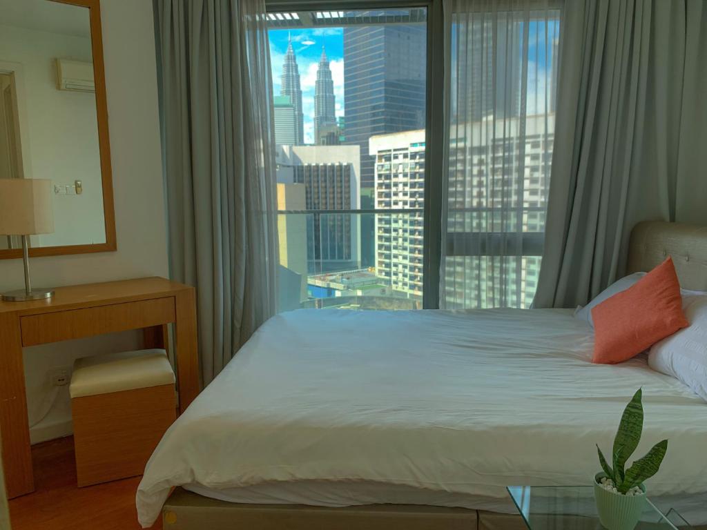 a bedroom with a bed and a large window at Bukit Bintang Fairlane Residences Twin Towers View in Kuala Lumpur
