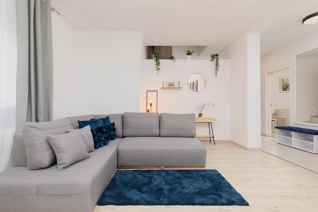 salon z szarą kanapą i niebieskim dywanem w obiekcie Metro Bemowo Two-Storey Apartment Pełczyńskiego by Renters w Warszawie