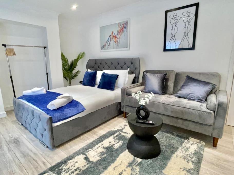 a bedroom with a bed and a couch at Stylish Cosy Studio Apartment in Kent
