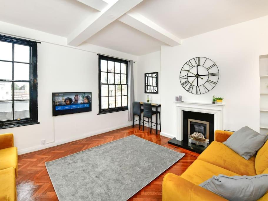 uma sala de estar com um sofá e um relógio na parede em Westgate House em Cardiff
