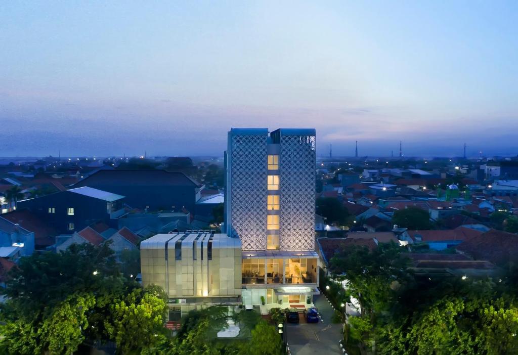 a lit up building with a city in the background at KHAS Tegal Hotel in Tegal