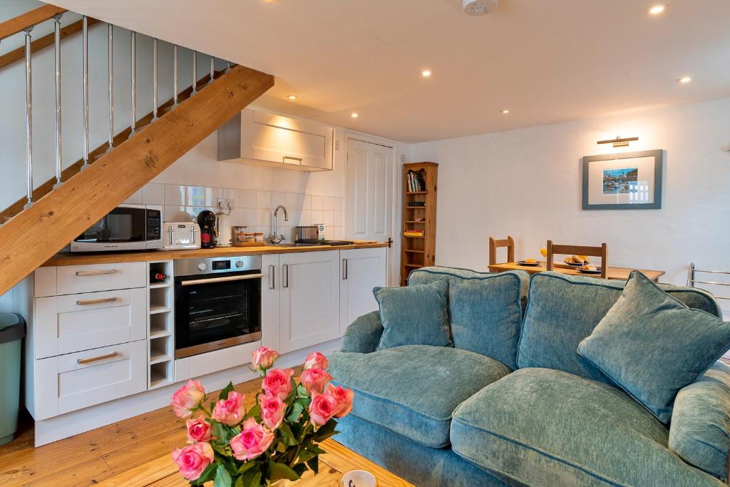 a living room with a blue couch and a kitchen at Finest Retreats - Salvay in Porthleven