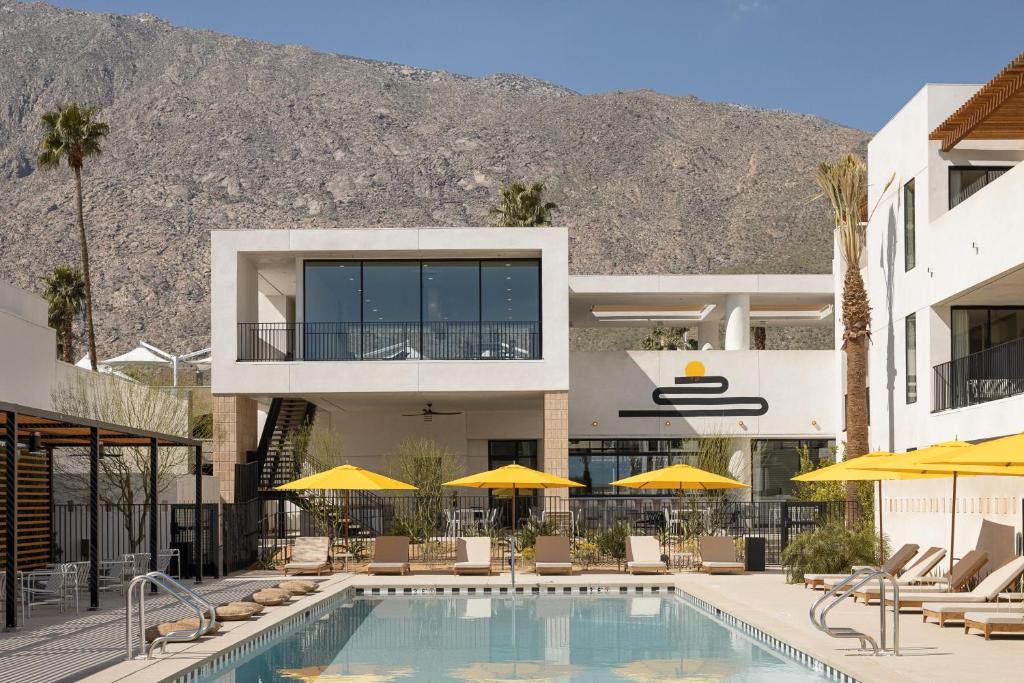 a hotel with a swimming pool with chairs and umbrellas at Drift Palm Springs in Palm Springs