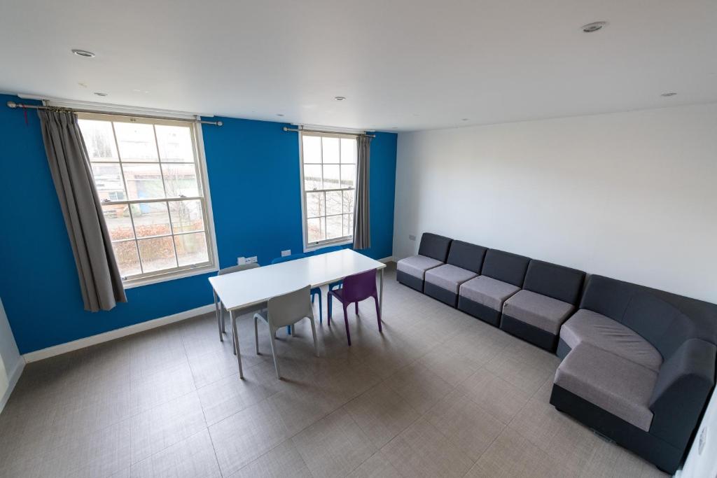 a waiting room with a table and chairs and blue walls at University of Bath City Accommodation in Bath
