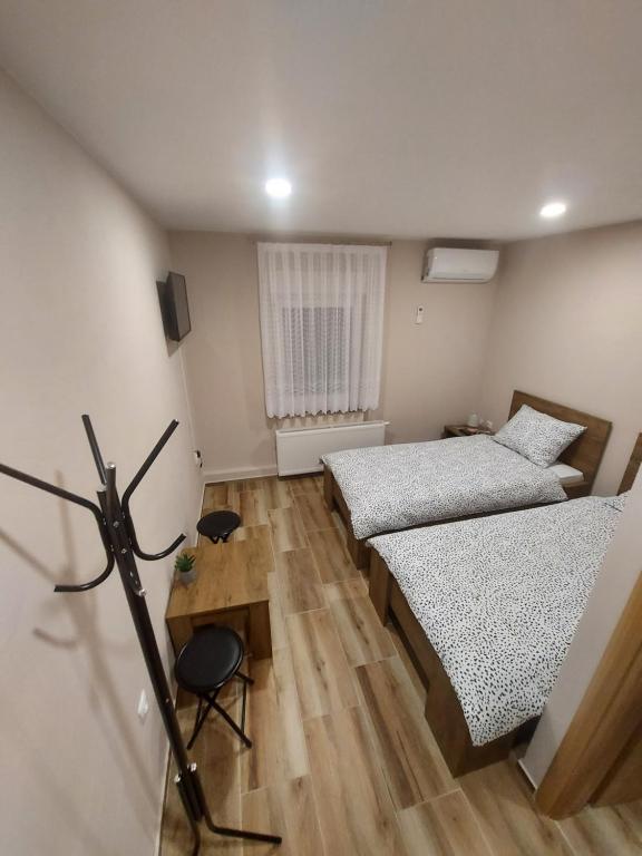Habitación pequeña con 2 camas y escritorio. en Kušaona Šokac en Trenkovo