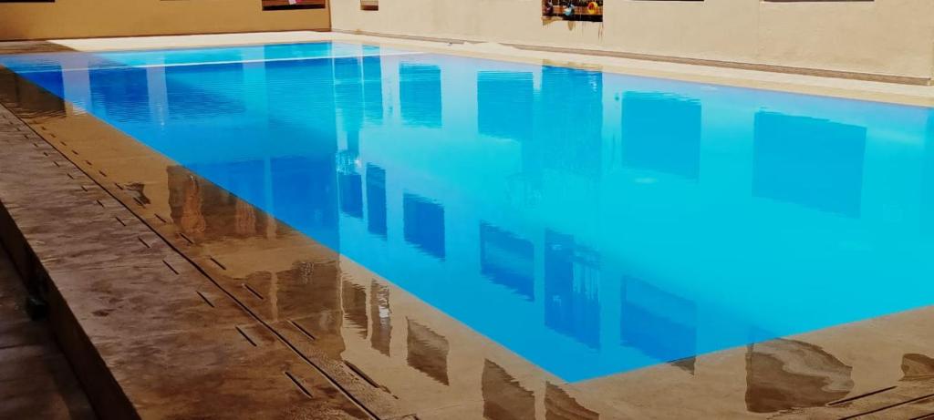 uma piscina com água azul num quarto em مراكش.شارع الحسن التاني em Aït Saïd