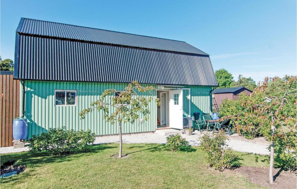 a green house with a black roof at Gorgeous Home In Klintehamn With Kitchen in Klintehamn