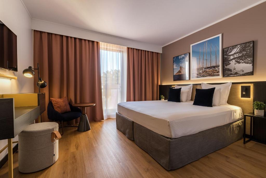a hotel room with a large bed and a television at Hôtel Villa M Marseille in Marseille