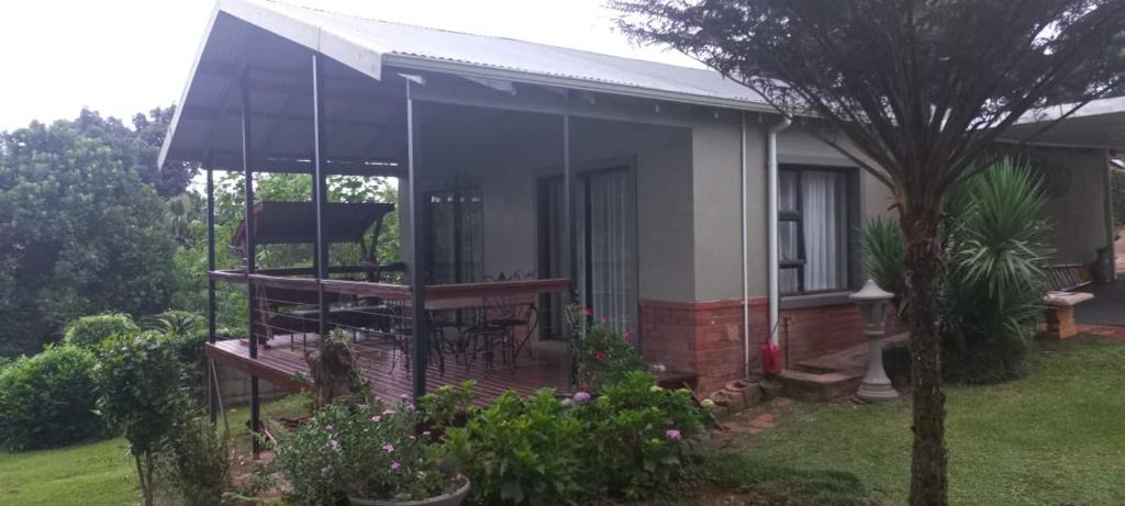 una casa con un porche cubierto en un patio en Forest View Cottage, en Pietermaritzburg