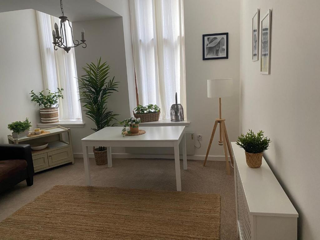 グラスゴーにあるInviting 1-Bed Apartment in Merchant Cityのリビングルーム(白いテーブル、鉢植えの植物付)