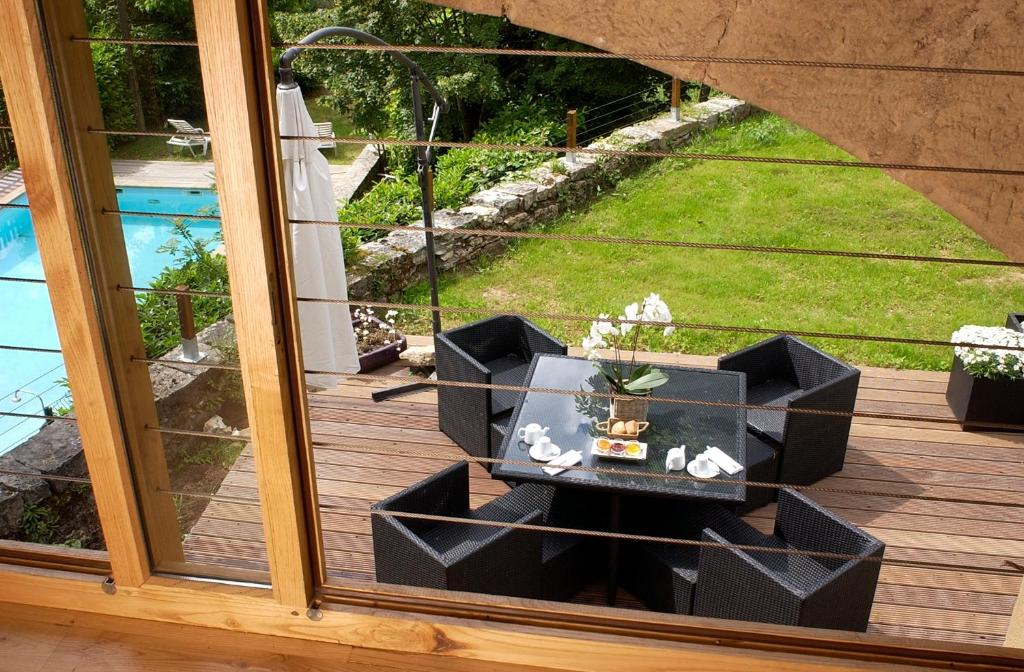 une table sur une terrasse avec vue sur une cour dans l'établissement Maison de famille, à Camboulit