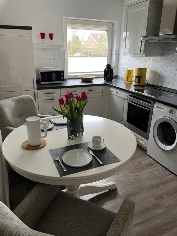 a kitchen with a white table with flowers on it at Ferienwohnung Südel App.2 in Malente