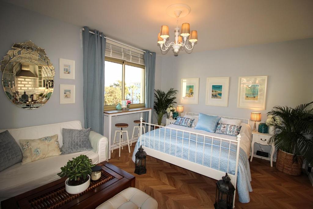 een slaapkamer met een bed, een bank en een raam bij La Californie Views in Cannes