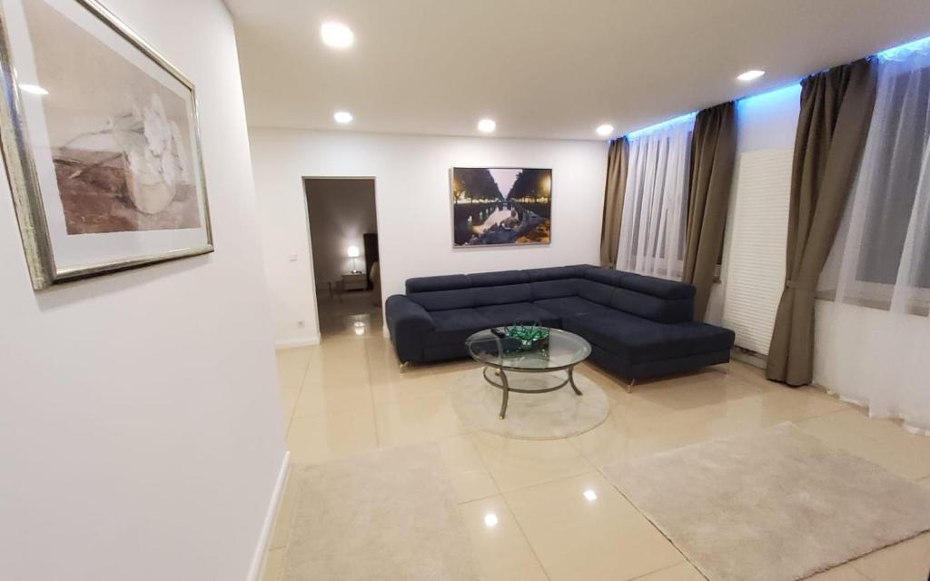 a living room with a blue couch and a glass table at 3 Zimmer Wohnung - Keine Party Wohnung !!! in Düsseldorf