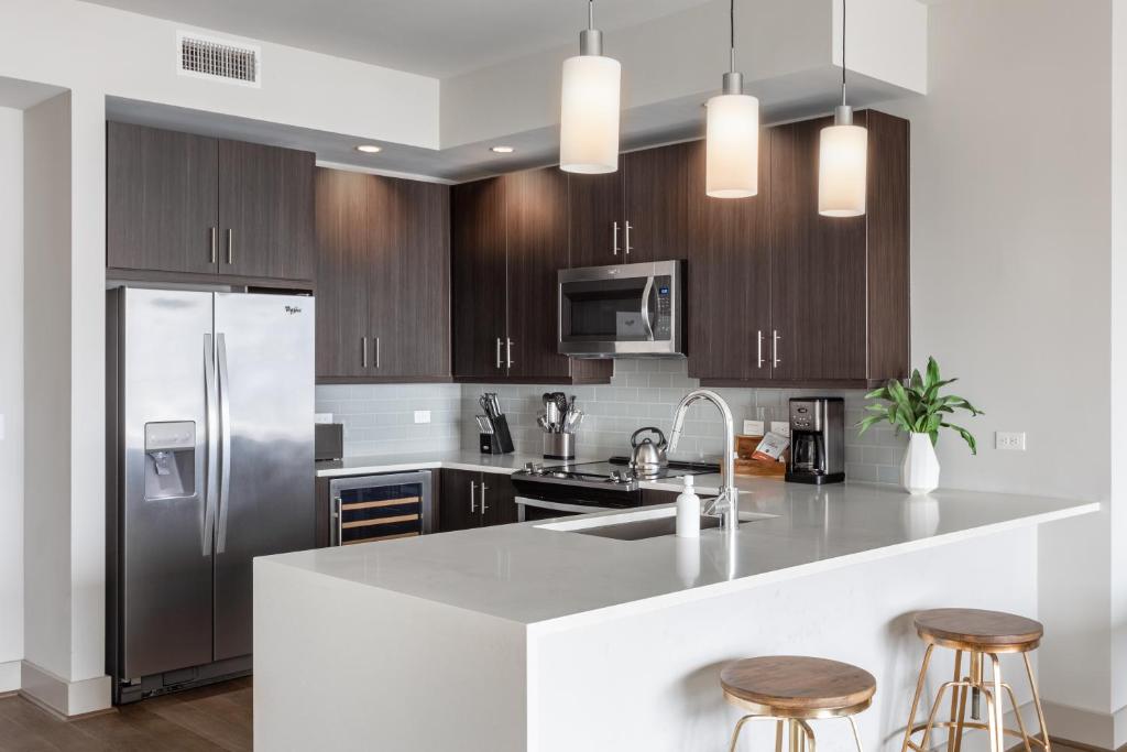 a kitchen with stainless steel appliances and wood cabinets at Locale Victory Park - Dallas in Dallas