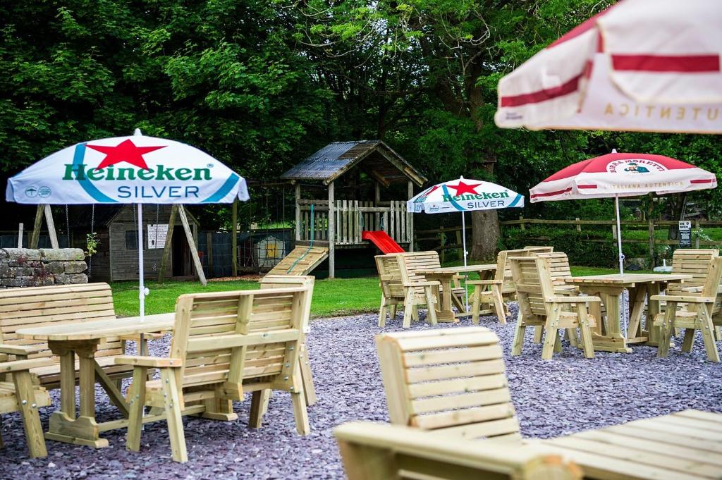 a group of tables and chairs with umbrellas at The Okeover Arms in Ashbourne