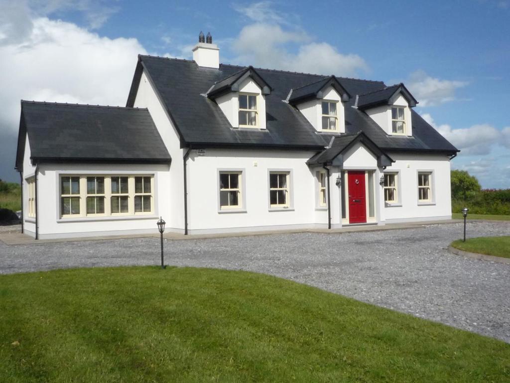 a large white house with a red door at Derryleigh House 