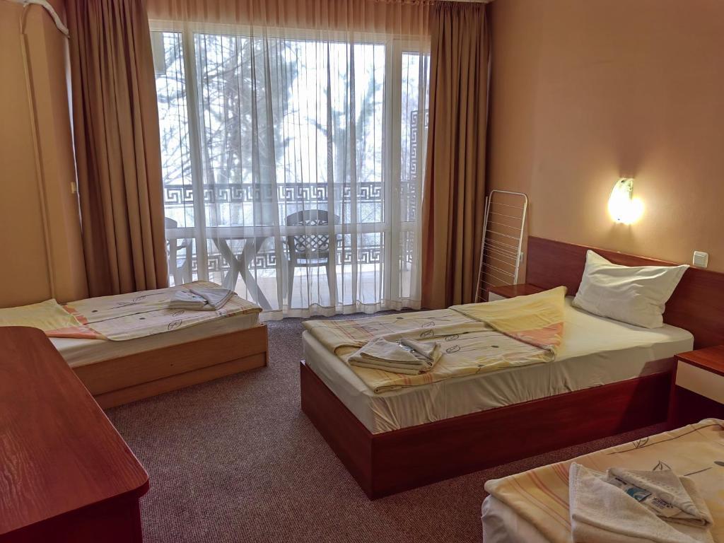 a hotel room with two beds and a balcony at Family Hotel Diana in Tsarevo