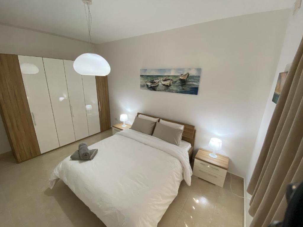 ein Schlafzimmer mit einem großen weißen Bett und zwei Lampen in der Unterkunft Tomi´s Unterkunft / Privatzimmer in Wien