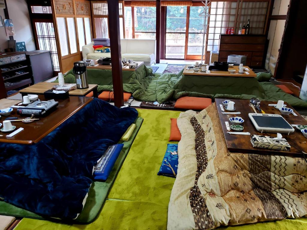 a living room with tables and a couch and a table at Guesthouse Tao in Tanabe