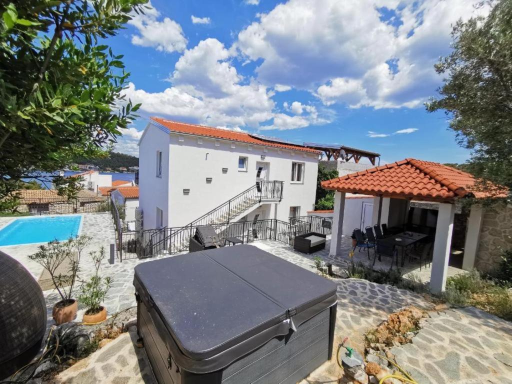 a bbq grill in the backyard of a house at Tisno Resort in Tisno