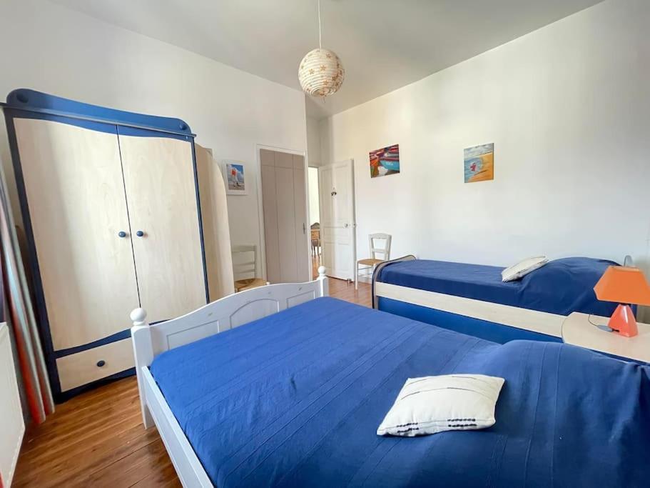 1 Schlafzimmer mit 2 Betten und blauer Bettwäsche in der Unterkunft Au Bon Port - Maison Bel Air in Les Sables-dʼOlonne