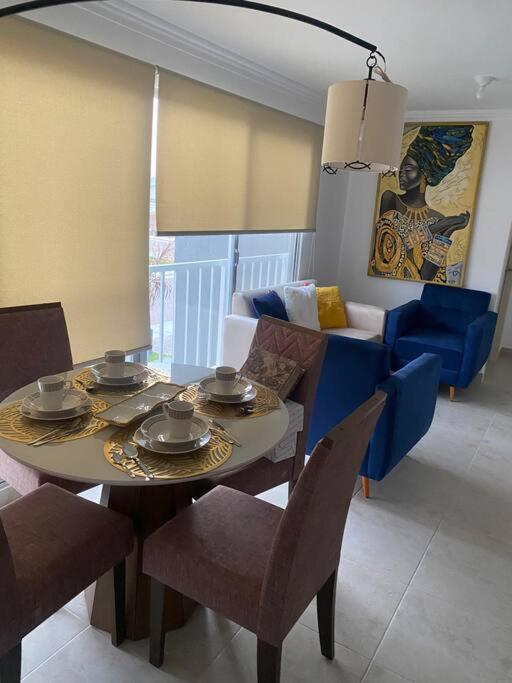 sala de estar con mesa, sillas y sofá en Departamento en La joya full, en Guayaquil