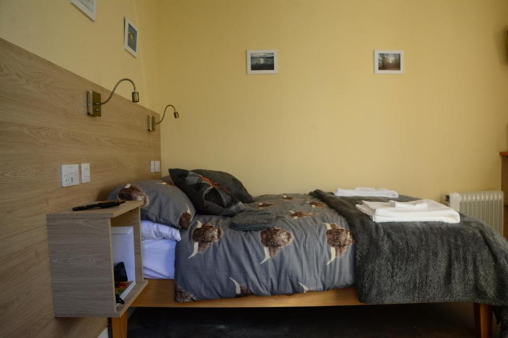 ein Schlafzimmer mit einem Bett und einem Tisch mit Handtüchern in der Unterkunft Room at the Back, 2 George Street in Avoch