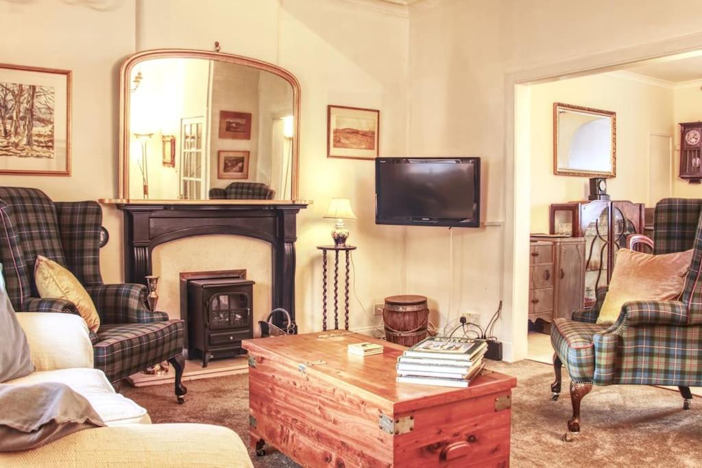 a living room with a fireplace and a tv at Fisherman's Cottage in Cockenzie