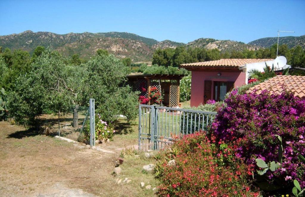 a fence in front of a house with flowers at Casetta Marieoria Chia in Chia