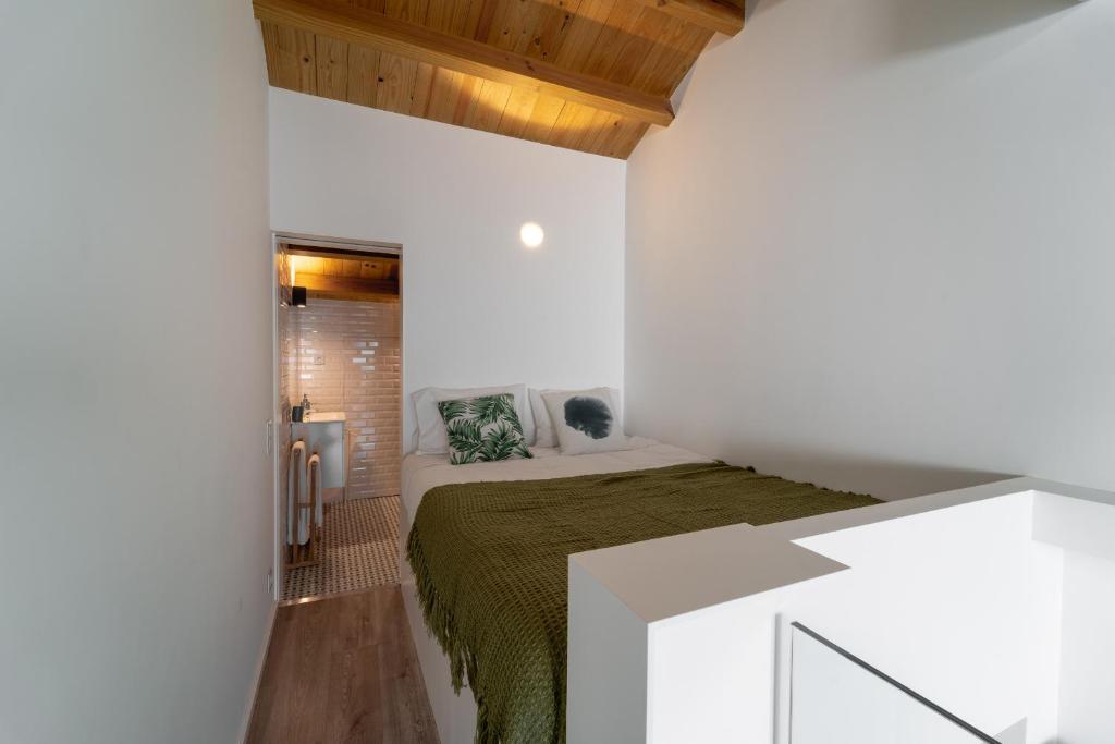 ein Schlafzimmer mit einem Bett in einem weißen Zimmer in der Unterkunft Casa Azul in Braga