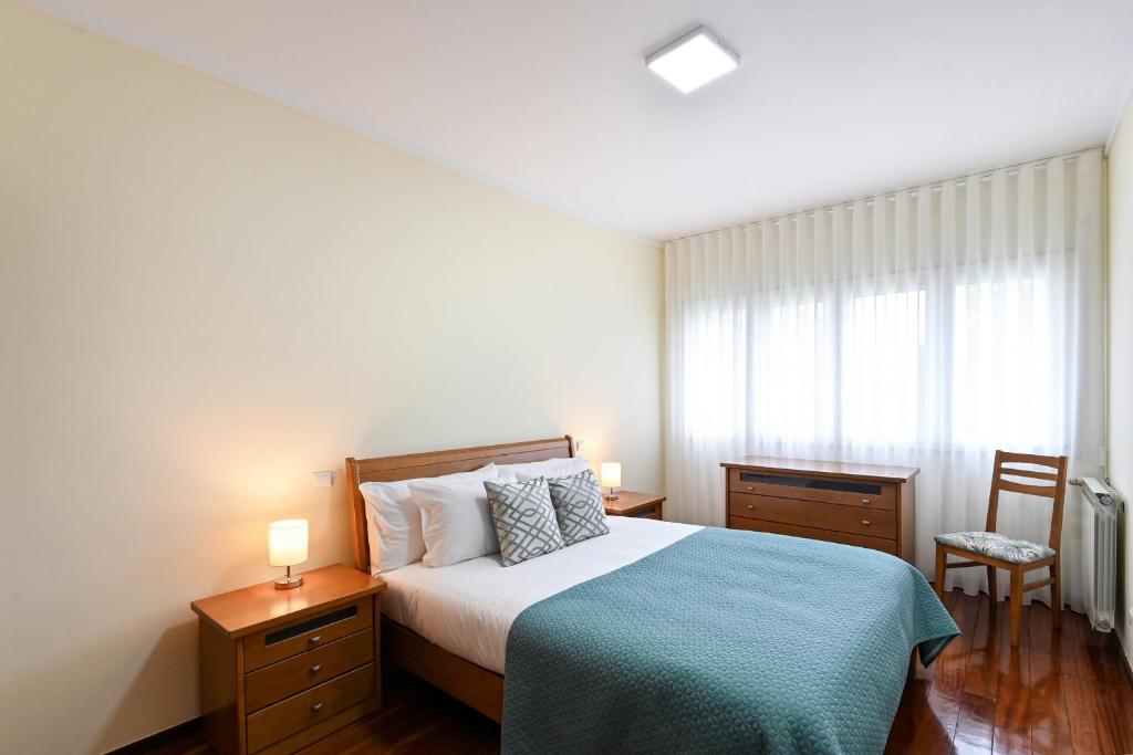 1 dormitorio con 1 cama con manta azul en Sé Apartamentos - Casa Cecília, en Braga