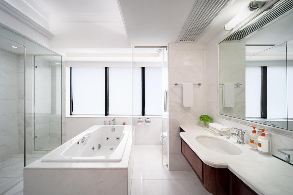 uma casa de banho branca com uma banheira e um lavatório em Crowne Plaza Hotel & Suites Landmark Shenzhen, an IHG Hotel - Nearby Luohu Border, Indoor heated swimming pool, Receive RMB100 SPA coupon upon check-in em Shenzhen