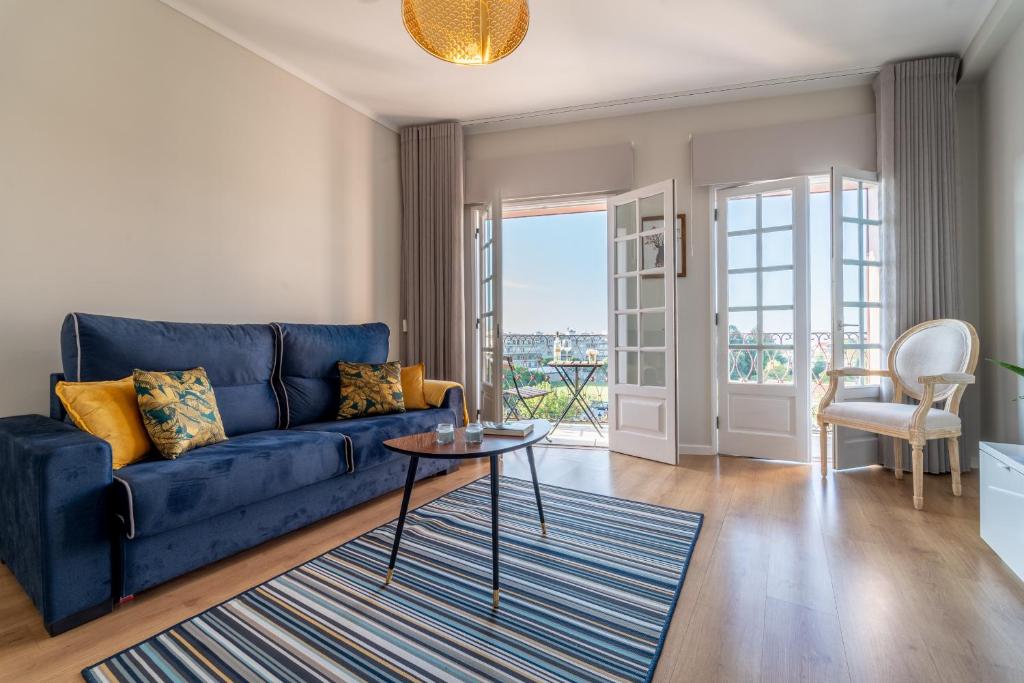 - un salon avec un canapé bleu et une table dans l'établissement Sé Apartamento - Casa do Chafariz, à Braga