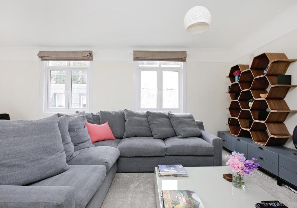 a living room with a gray couch and a table at Hyde Park Mews London w2 - Zone 1 in London