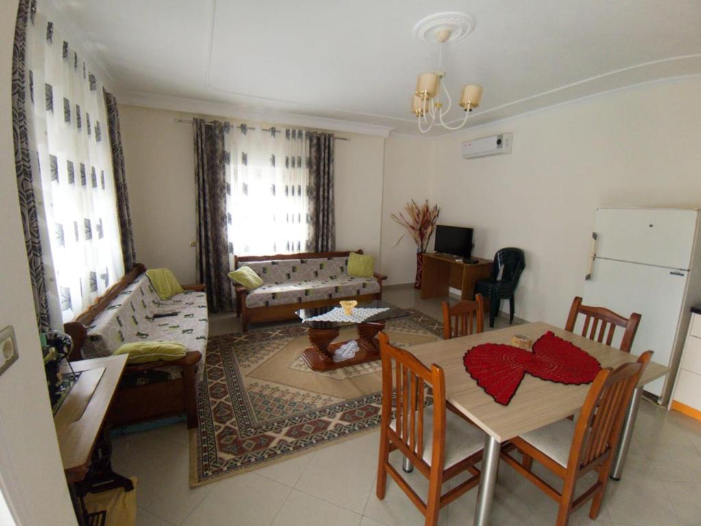 ein Wohnzimmer mit einem Tisch und Stühlen sowie ein Wohnzimmer in der Unterkunft Darius Apartment in Sarandë
