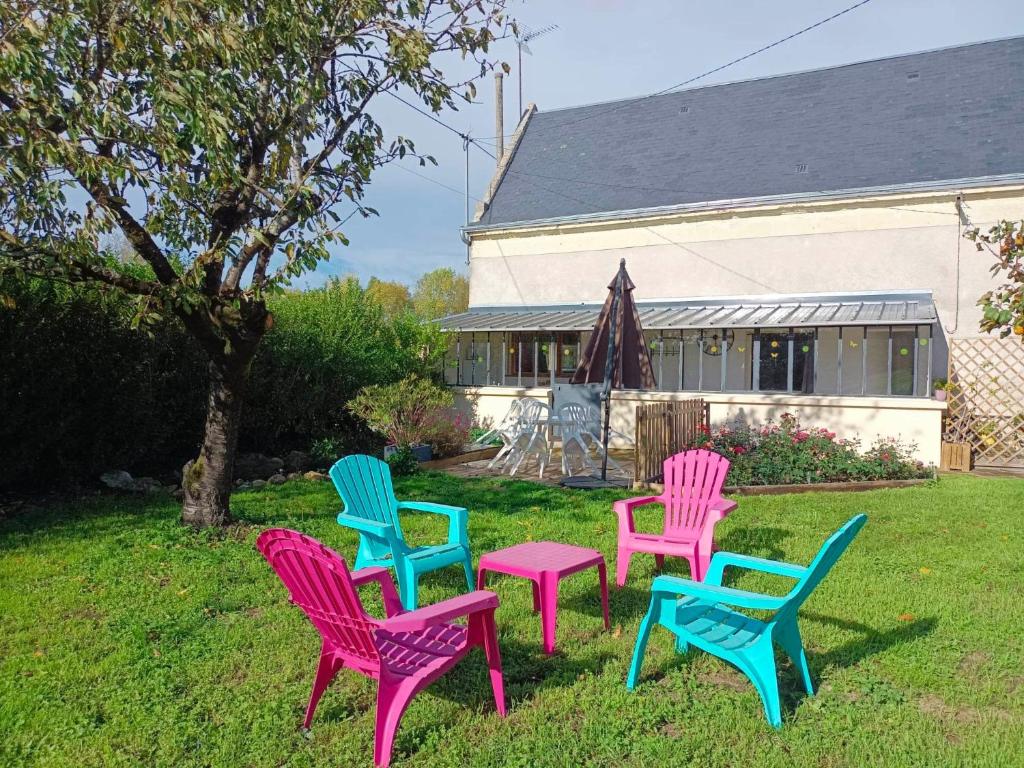 um grupo de cadeiras coloridas sentadas na relva em Gîtes du Franc Rosier em Rigny-Ussé