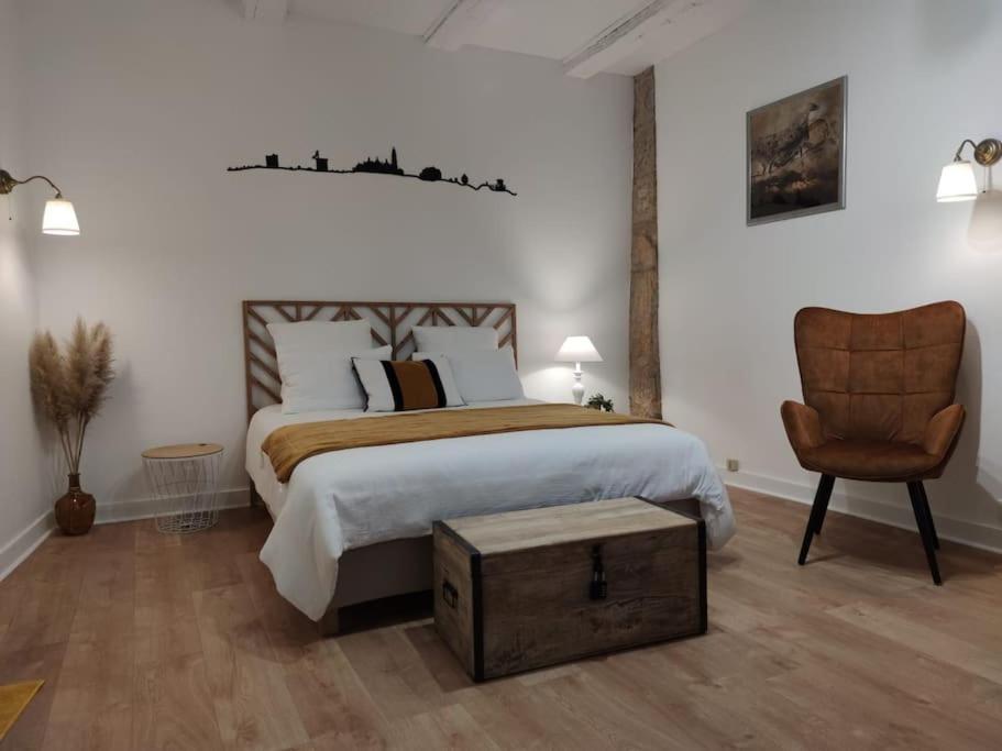 een slaapkamer met een groot bed en een stoel bij Studio * Le Petit Nicolas * in Périgueux