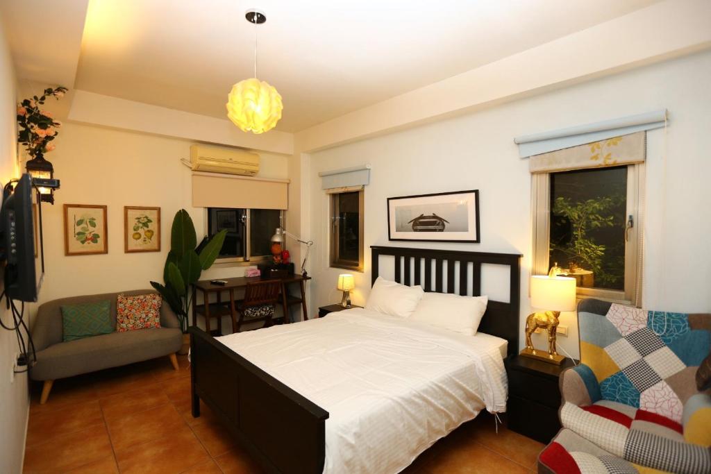 a bedroom with a bed and a couch and a chair at Star Wish B&amp;B in Dongshan