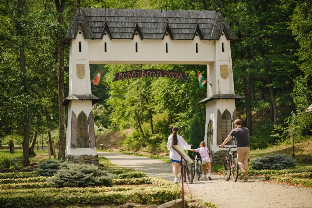 a family walking their bikes through a gate in a park at Voevodyno Resort in Tur'ya Pasika