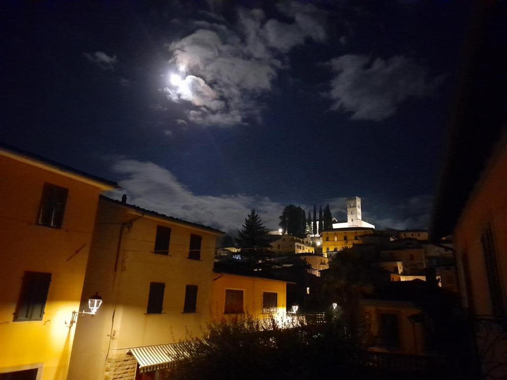 Une lune dans le ciel au-dessus d'une ville la nuit dans l'établissement Casa Fiorina, à Barga