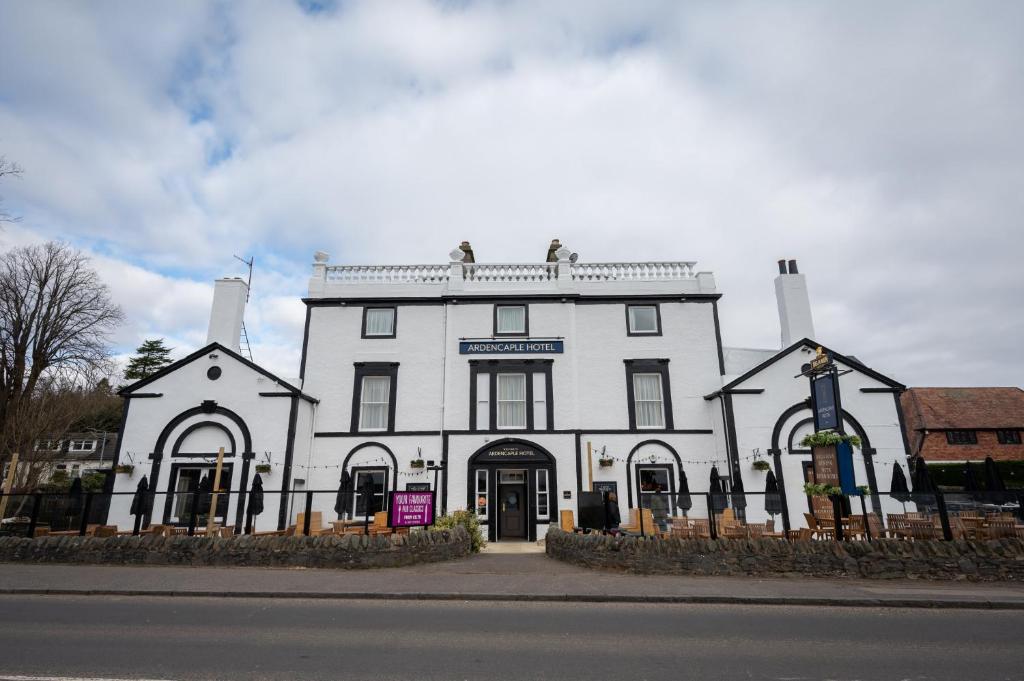 a white building sitting on the side of a street at Ardencaple Hotel by Greene King Inns in Rhu