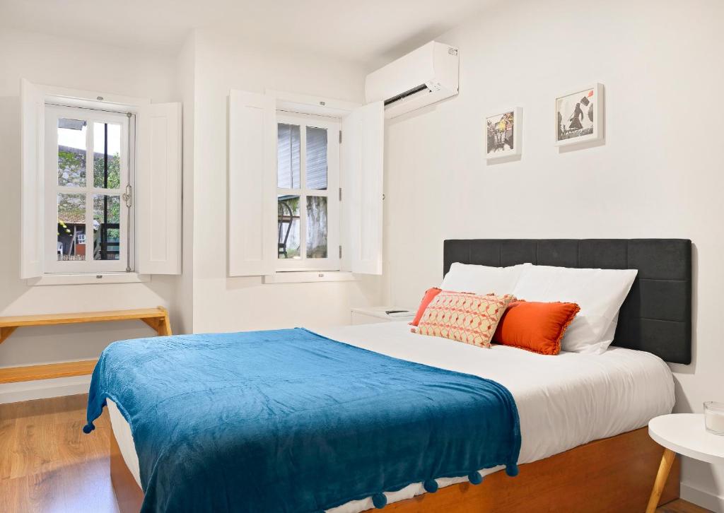 una camera da letto con un letto grande con due finestre di Porta 34 Apartments a Braga